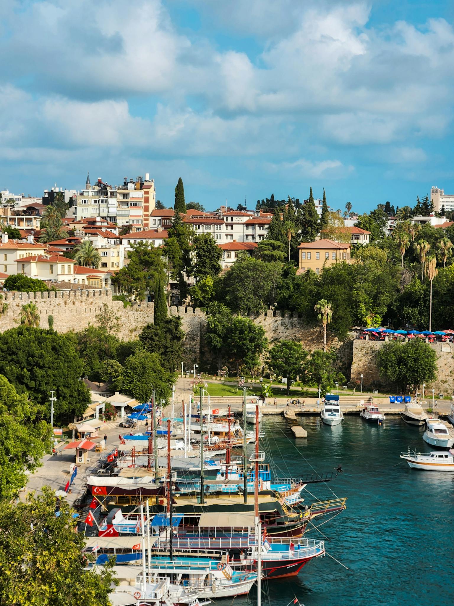 Beautiful harbor and cityscape with boats and historic architecture under a bright sky.