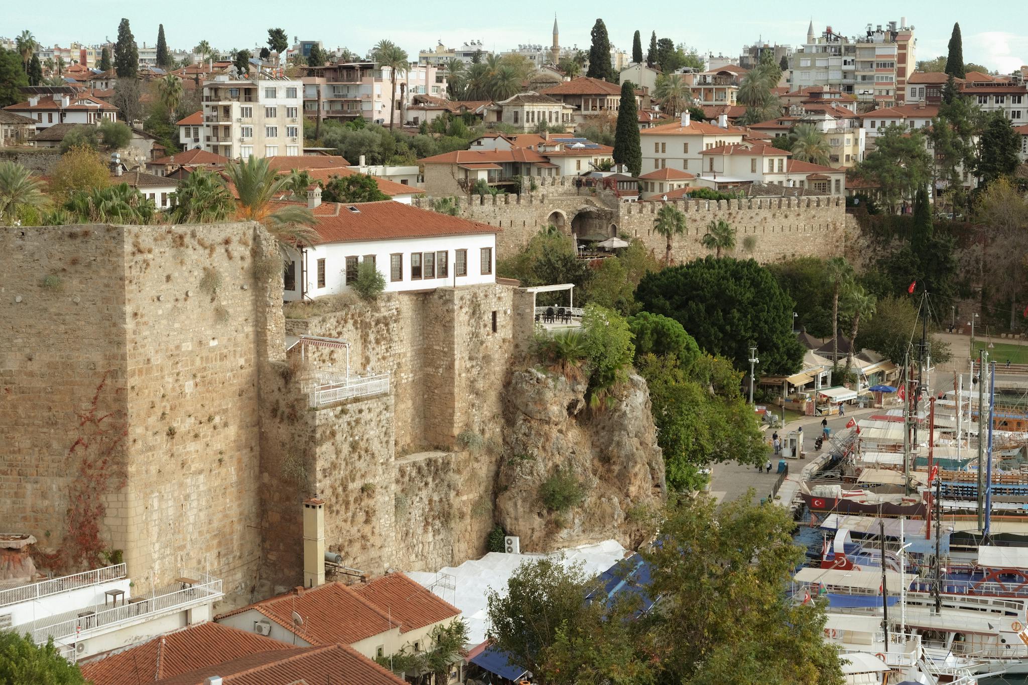 Explore the historic harbor and old town of Antalya, Turkey, with its ancient walls and Mediterranean charm.
